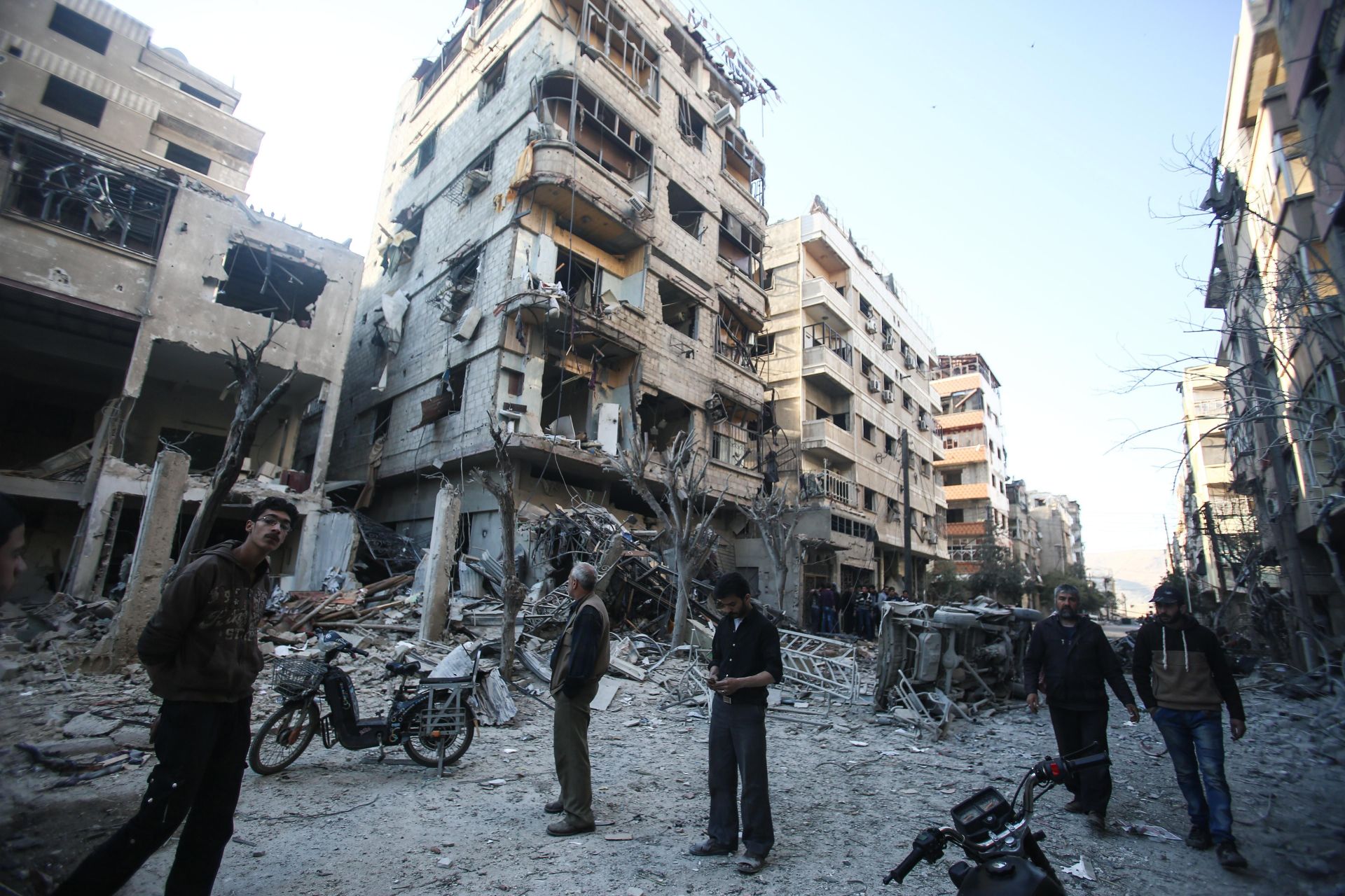 Gente inspecciona edificios después del ataque aéreo en Douma, Siria.